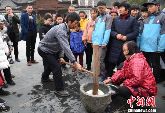 2018年2月9日，婺源县江湾村村民在村头打麻糍。